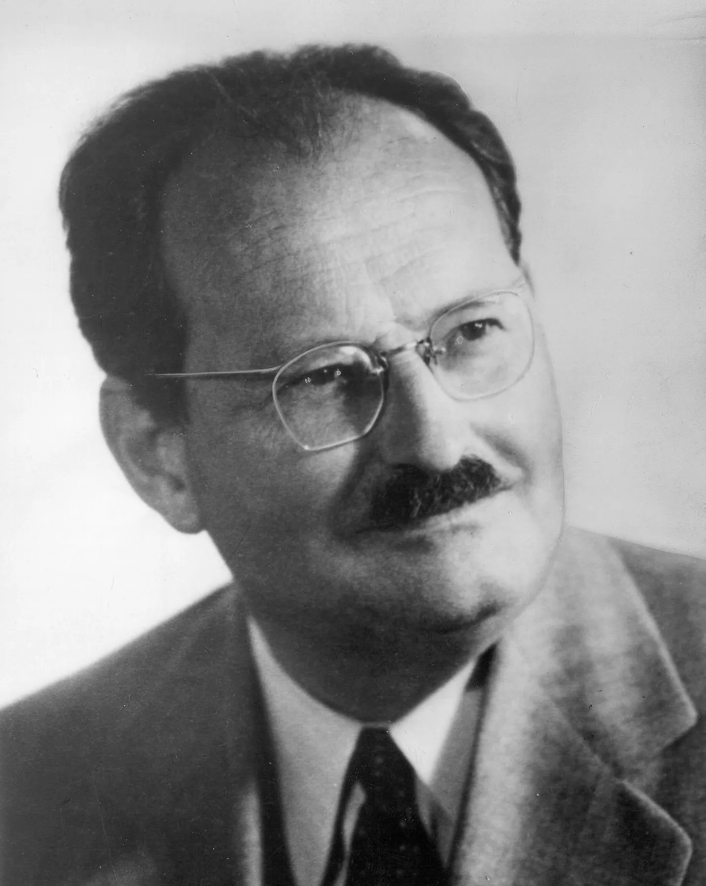retrato en blanco y negro de un hombre con gafas y traje