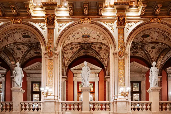 Sierlijk interieur van de Weense Staatsopera met gewelfde plafonds, gouden details en witte beelden
