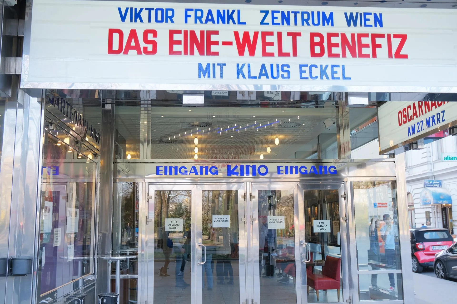 Entrada al Viktor Frankl Zentrum Wien con un cartel sobre las puertas de cristal que muestra el nombre del centro y el título de un evento.