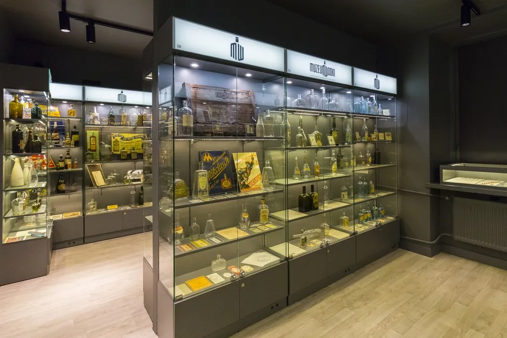 Wnętrze Muzeum Wódki ze szklanymi gablotami wypełnionymi butelkami i artefaktami