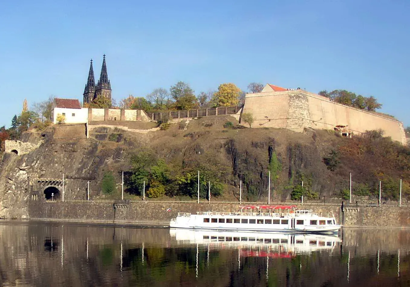 Fortaleza de Vyšehrad con una basílica y un barco de crucero fluvial en el río Moldava