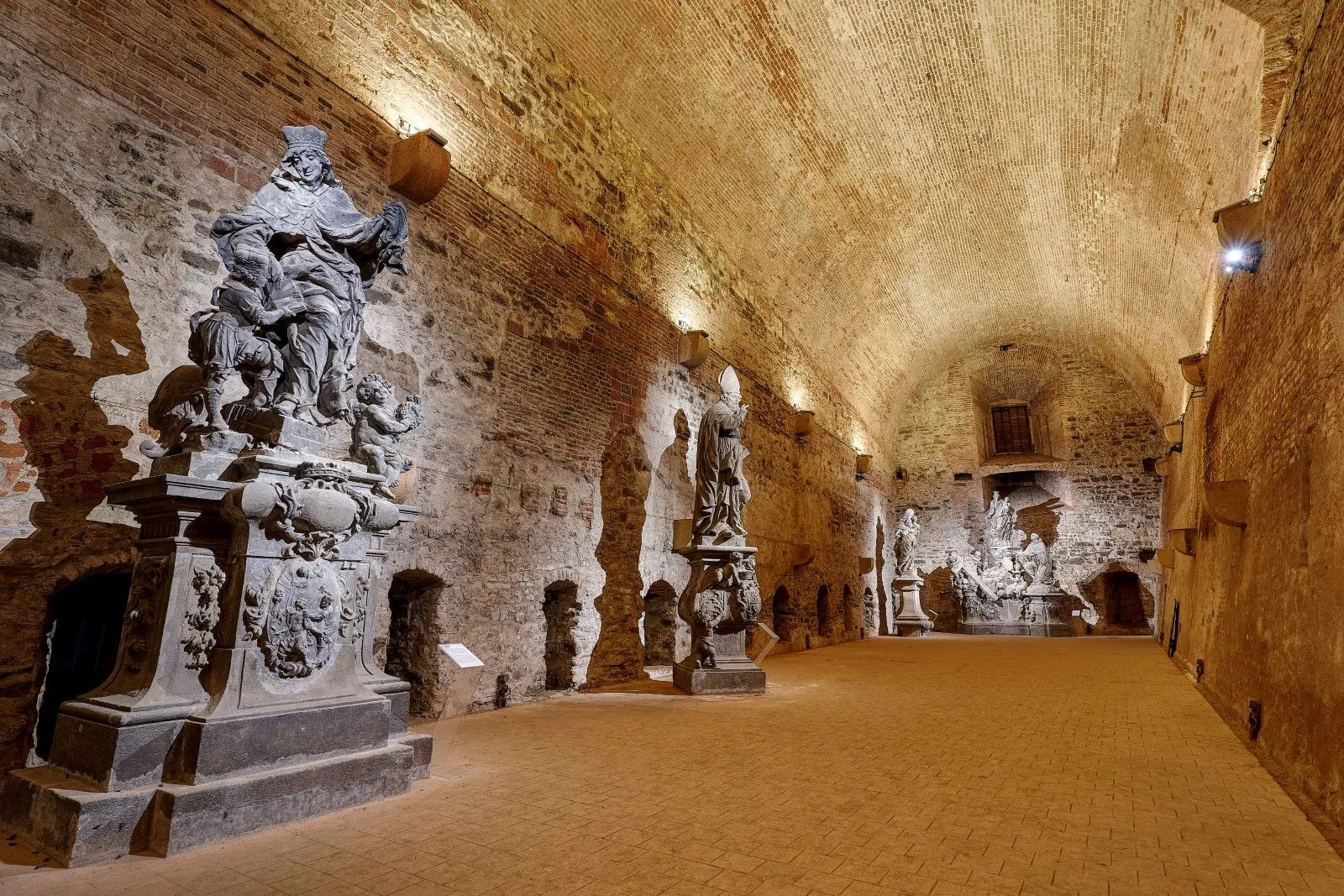 Corredor de piedra abovedado con estatuas históricas y esculturas en las casamatas de Vyšehrad