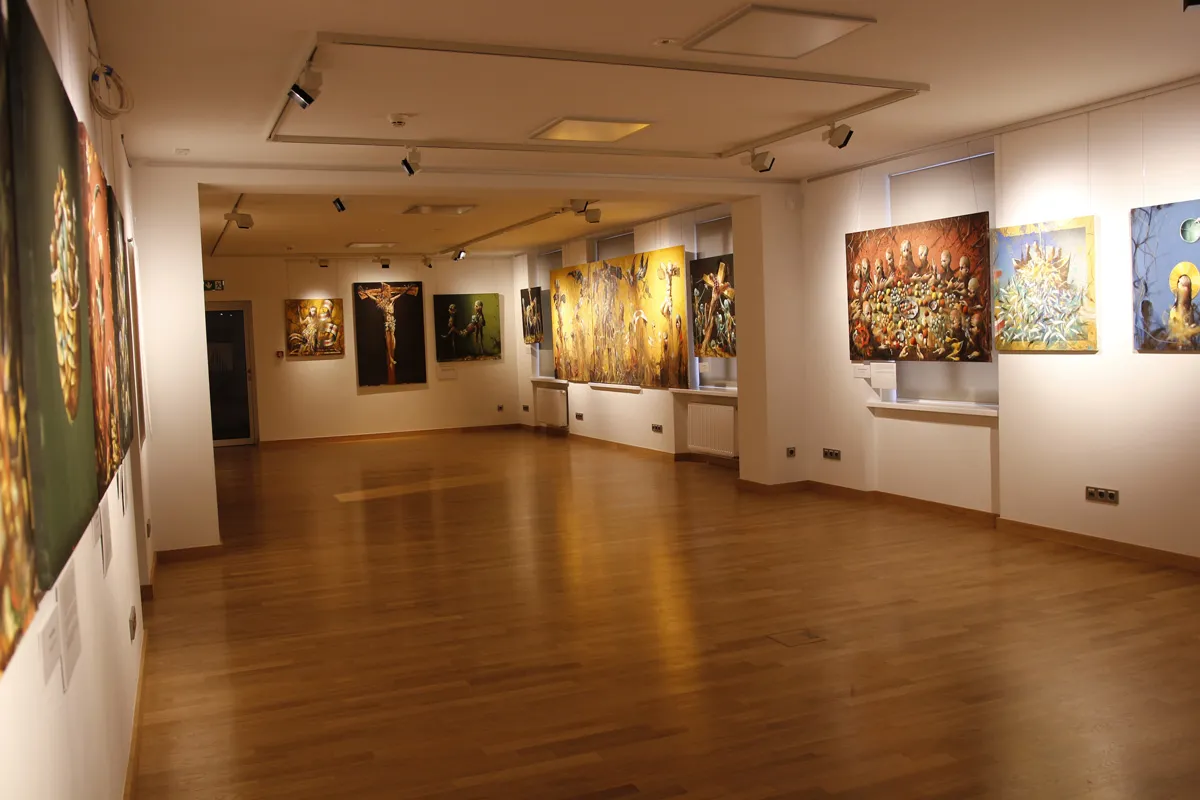 Galerij met schilderijen op witte muren en houten vloeren