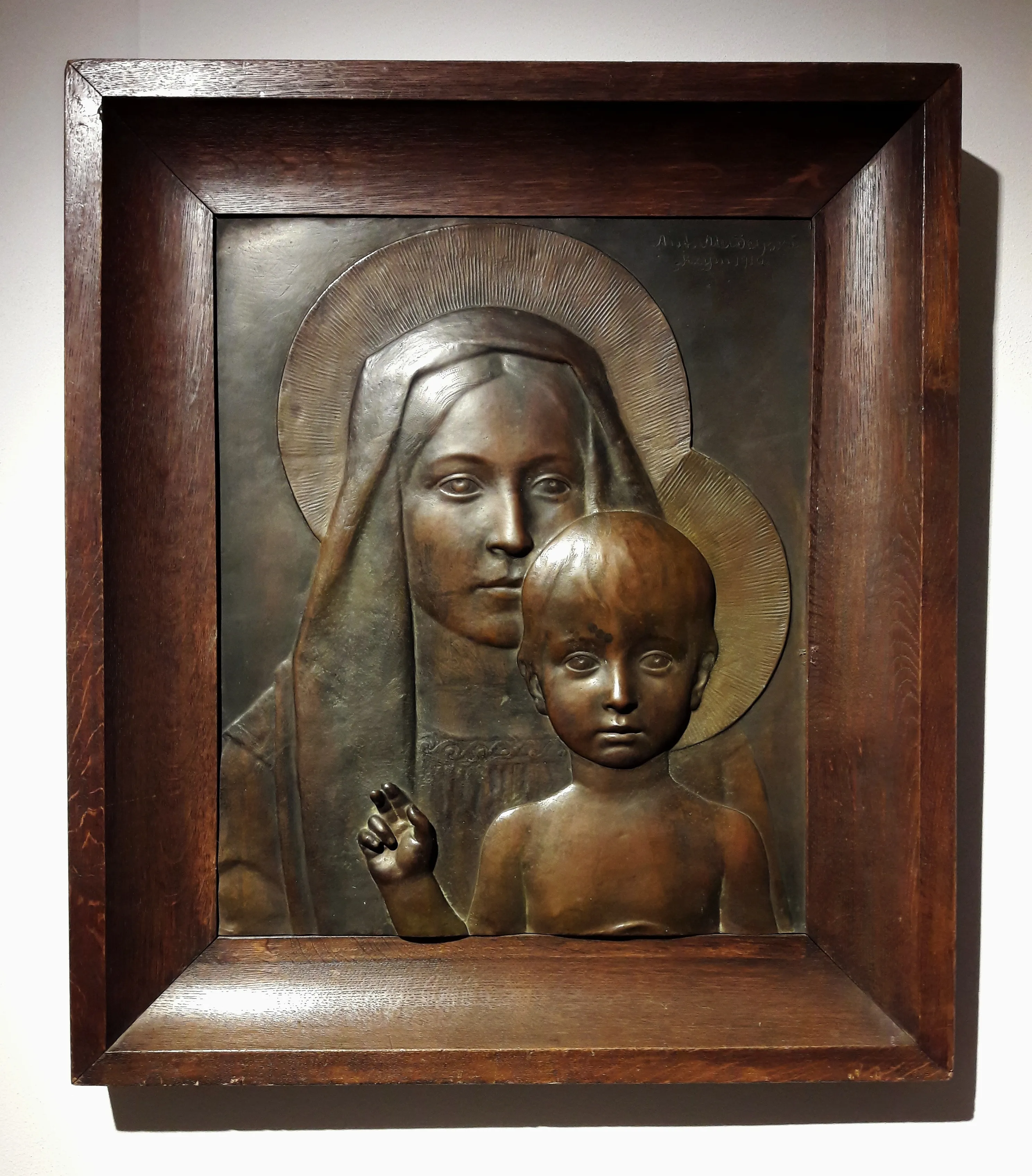 Bronzen reliëfsculptuur van de Madonna en Kind in een houten lijst