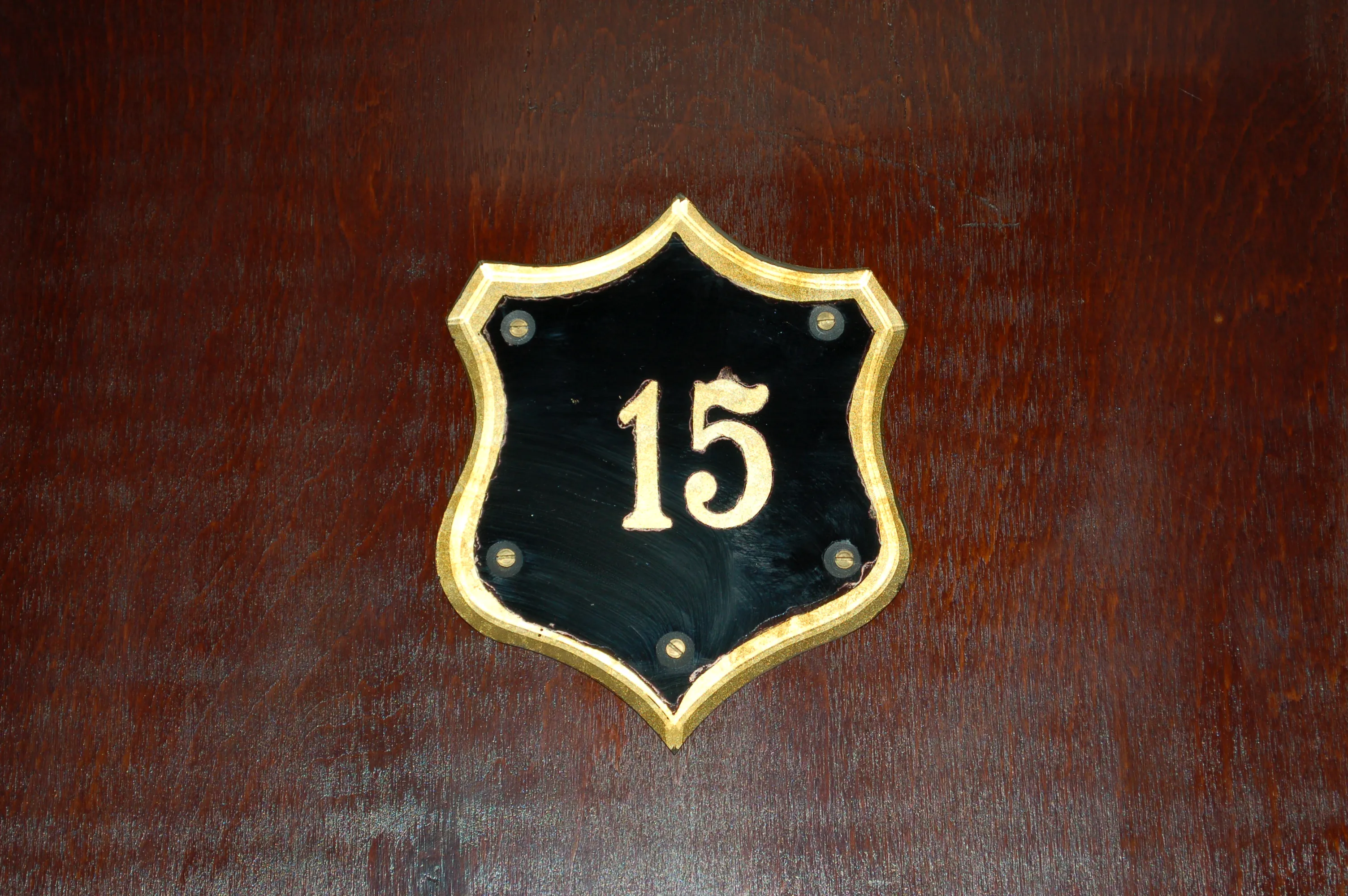 shield-shaped plaque with number 15 on black background