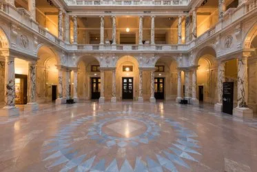 Wielka hala z ozdobnymi kolumnami, mozaikową podłogą i klasycystyczną architekturą