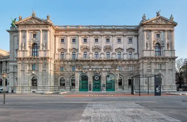 Budynek neoklasycystyczny z ozdobnym kamieniarstwem i zielonymi drzwiami wejściowymi