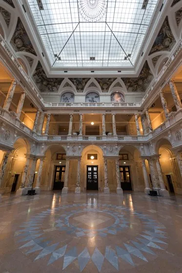 Sztuczna sala wewnętrzna ze szklanym sufitem, marmurową podłogą i klasyczną architekturą