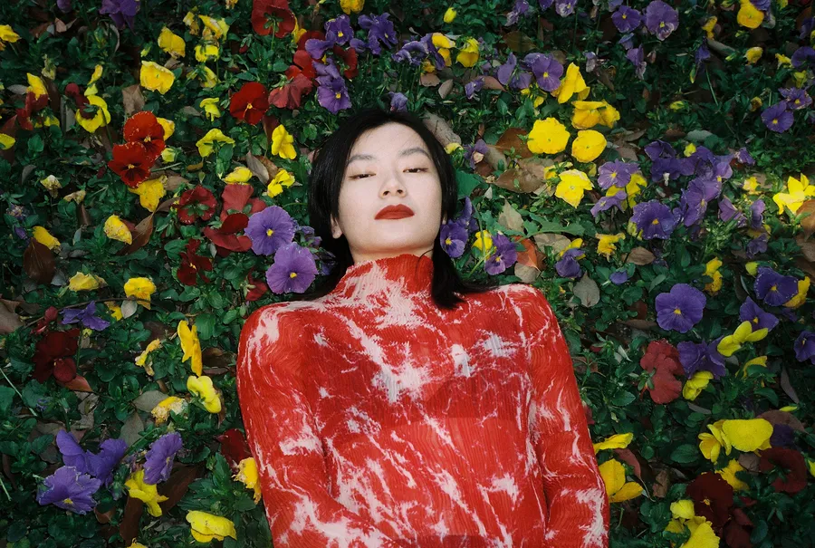 persona tumbada en un campo de flores coloridas