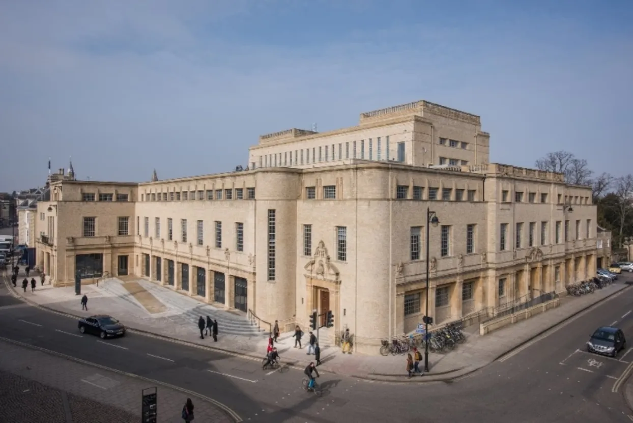Exterior view of the Weston Library, a large Art Deco stone building on a street corner with pedestrians and vehicles