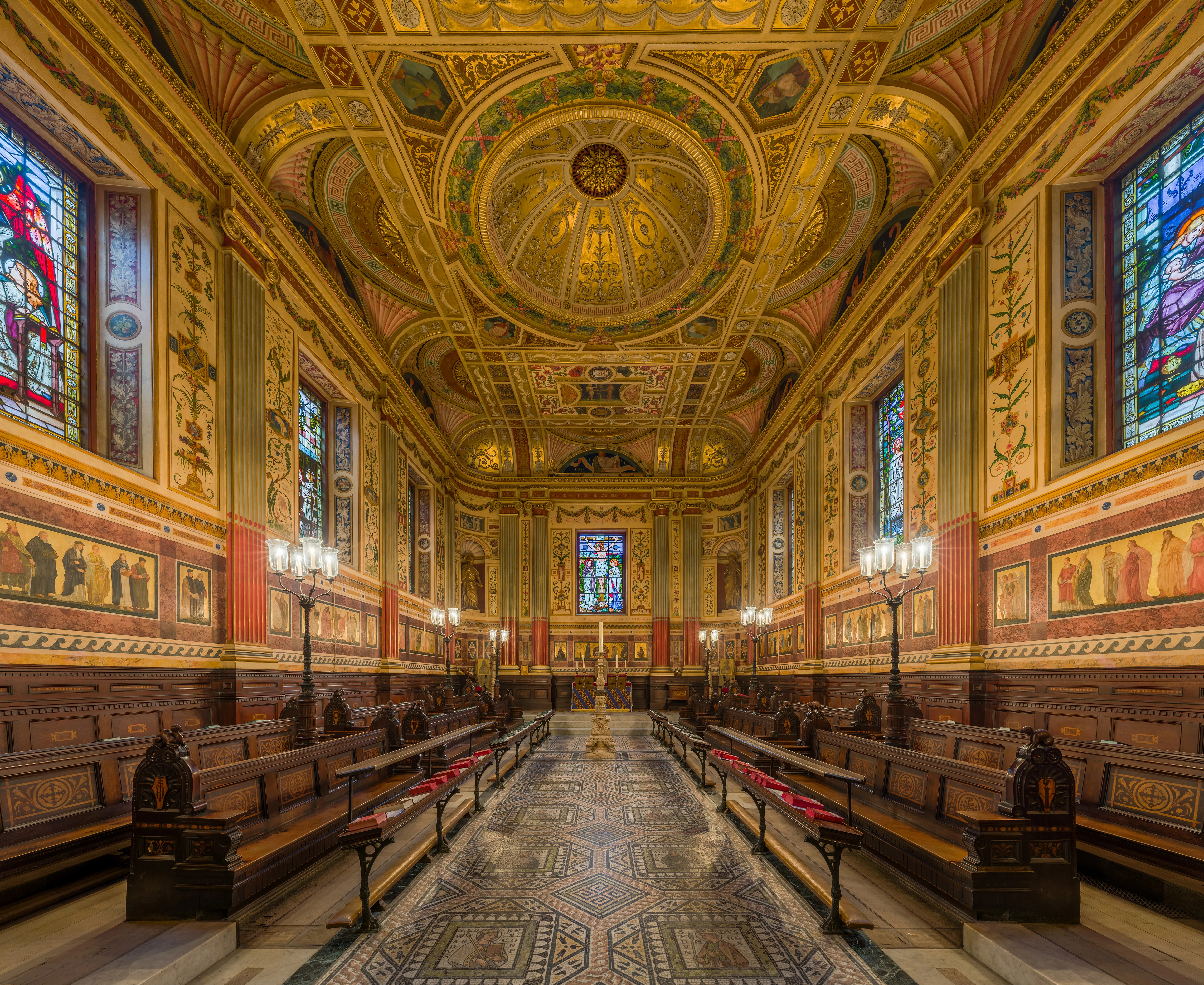 Wnętrze kaplicy Worcester College ukazujące długą nawę z drewnianymi ławkami, witrażami i ozdobnie malowanym sufitem.