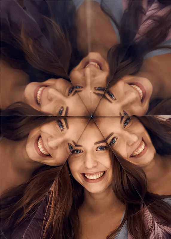 A woman's face reflected in a kaleidoscopic mirror pattern