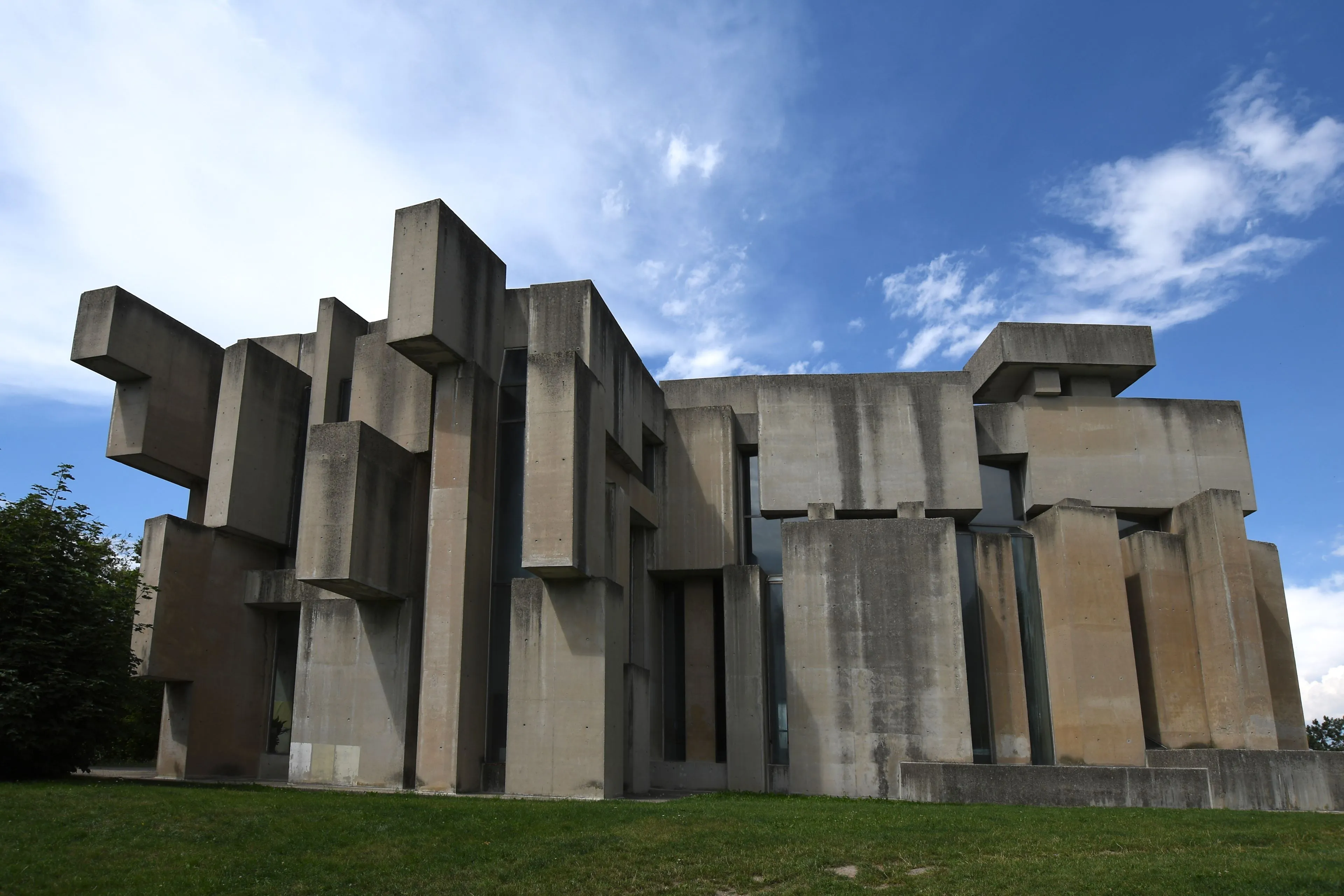 Modern betonnen kerkgebouw met geometrische gestapelde blokken onder een blauwe lucht