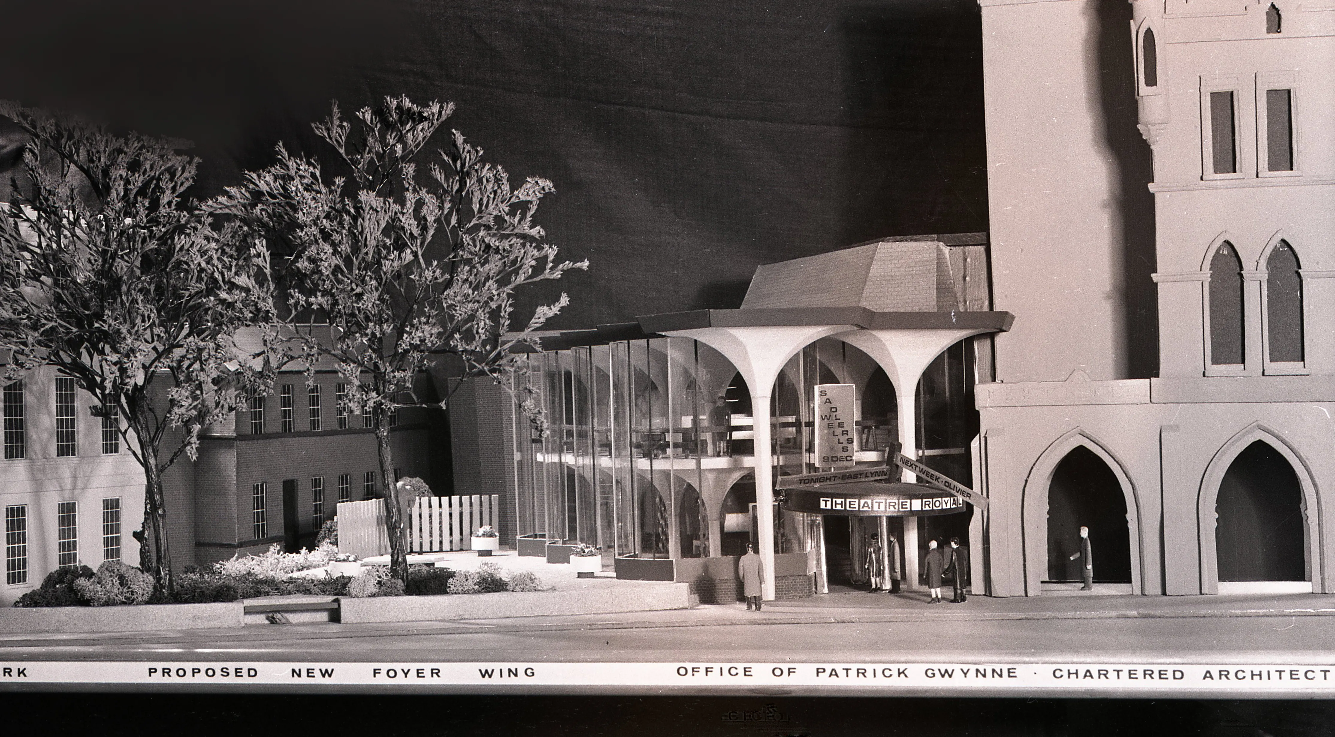Fotografía en blanco y negro de un modelo arquitectónico a escala que muestra la propuesta de la nueva ala del vestíbulo del York Theatre Royal junto al edificio existente con arcos góticos, con el texto 'Proposed New Foyer Wing, Office of Patrick Wynne Chartered Architect' en la parte inferior.