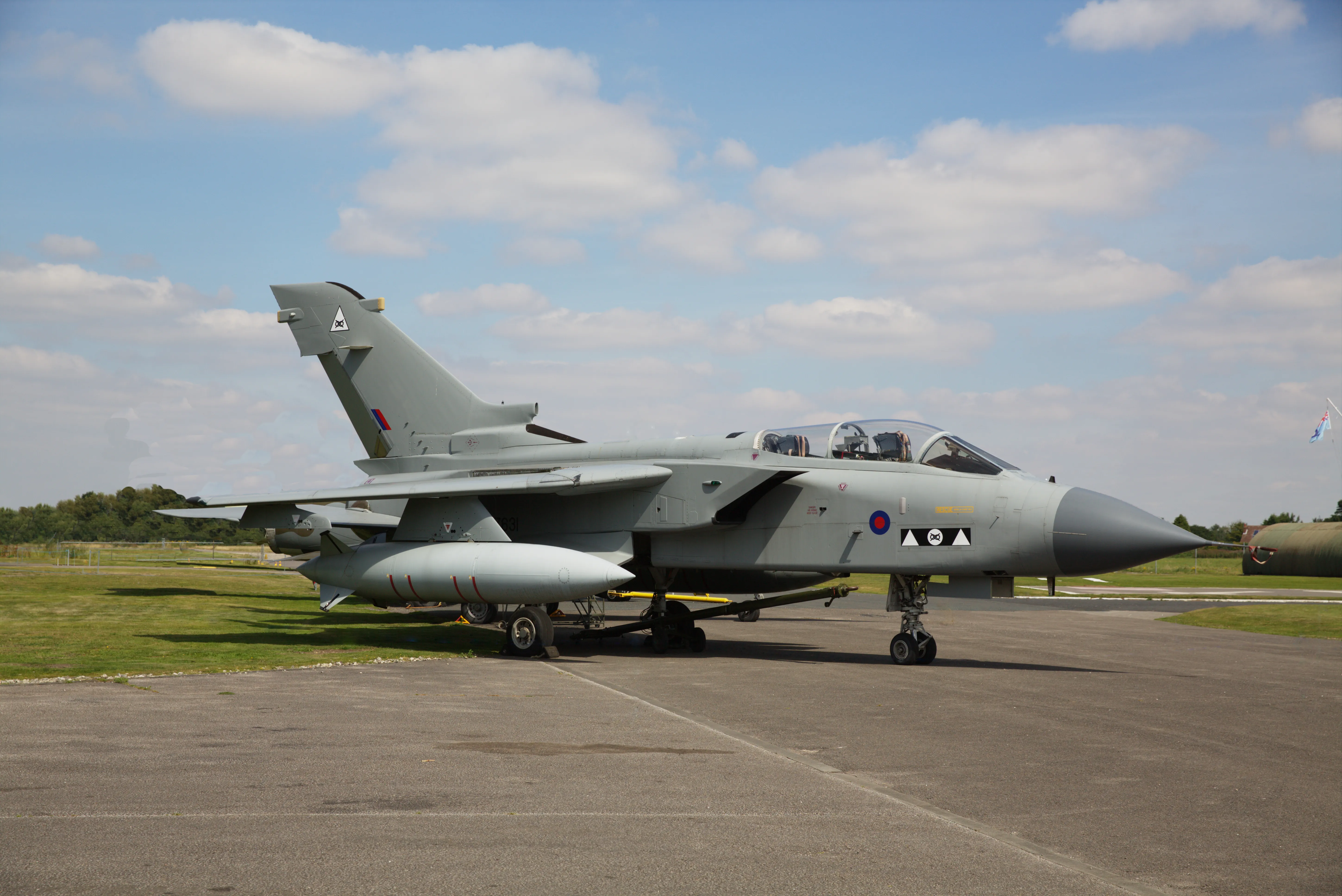 Panavia Tornado GR4 militair straalvliegtuig geparkeerd op het asfalt onder een blauwe lucht met verspreide witte wolken